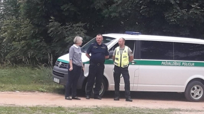 Cilvēki pie policijas mašīnas